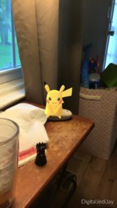 Short wishes to inform you how Pokemon GO is slowing down game accessibility. Seen is gameplay in someone's house catching a Pikachu.