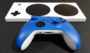 Image shows a blue and white Xbox controller in front of a Xbox Adaptive Controller